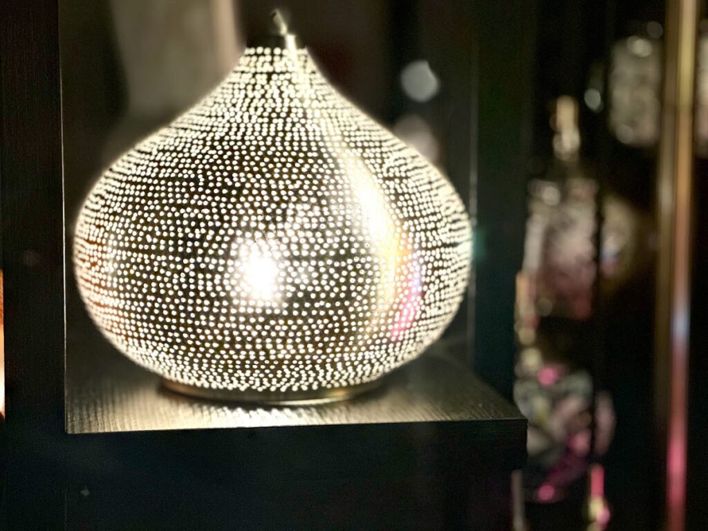 Lampe d'ambiance égyptienne faite main, projetant un motif de lumière complexe, disponible à Nakshedil Boutique, Remich.